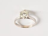 une image d'une bague en diamant sur une surface blanche