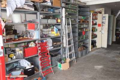 a garage with a lot of shelves and a ladder in it