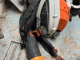 a chainsaw that is laying on the ground next to other tools