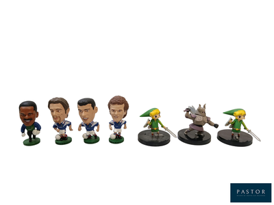 Plusieurs figurines représentant des personnages de la légende de Zelda sont alignées en rangée.