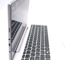 a laptop computer sitting on a white surface with a keyboard