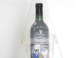 une bouteille de vin exposée dans une vitrine transparente