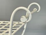 a white metal bench with a metal handle on it