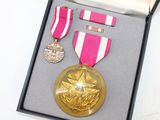 a gold medal with a star on it in a box