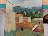 someone is holding a painting of a view of a small town