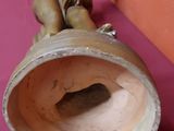 une statue représentant un garçon assis sur un vase
