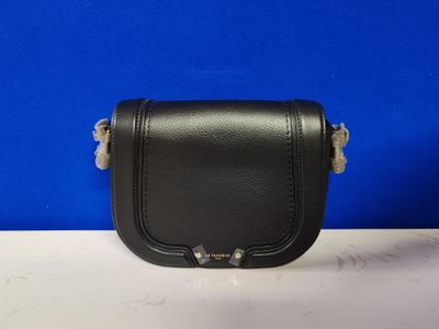 un petit sac à main en cuir noir muni d'une poignée en métal
