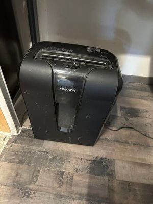 Le carton noir se trouve par terre, à côté de la porte.