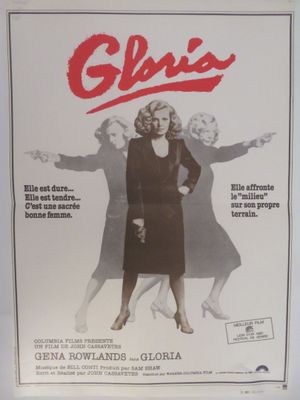 une vieille affiche de cinéma représentant une femme en robe noire et un homme en costume