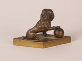 an image of a bronze statue of a lion on a ball