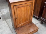 une petite armoire en bois posée sur le trottoir