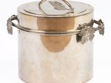 a silver container with a handle and a leaf on it