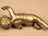 a bronze figurine of a baby laying on its back