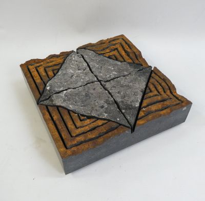 a close up of a small stone object on a white surface