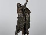 a bronze statue of a woman holding a sword on a rock