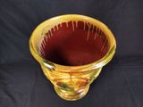 a yellow vase that is sitting on a black background