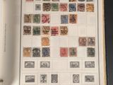 un livre ouvert avec des timbres, posé sur une table