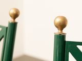 a green chair with a gold ball on top of it
