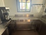 a stainless steel kitchen with a coffee maker on the counter