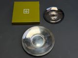 a silver plate and a green box on a table