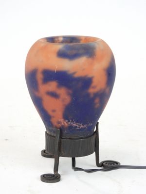 a blue and orange vase sitting on a black stand