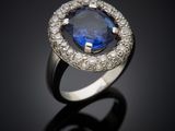 a blue sapphire and diamond ring on a black surface