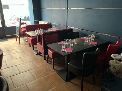 tables and chairs in a restaurant with blue walls and red chairs