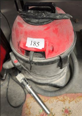 un aspirateur rouge posé par terre à côté d'un outil