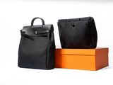 two black and orange bags sitting next to each other on a white surface