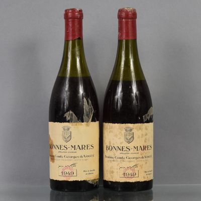 two bottles of wine sitting on top of a table next to each other