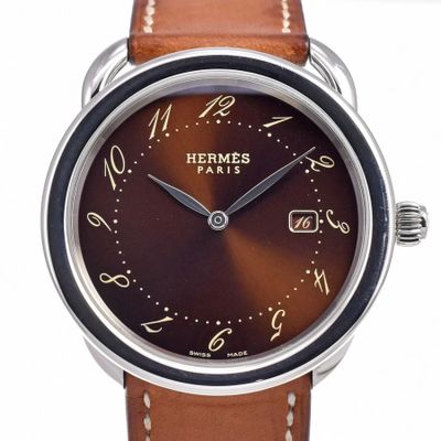 a close up of a wrist watch with a brown dial