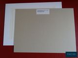 two pieces of paper with a label on them sitting on a red surface