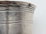 a close up of a silver container on a white surface