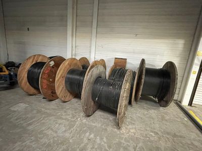 many spools of different sizes and colors in a warehouse