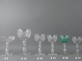 seven wine glasses lined up in a row on a table
