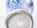 a blue and white vase sitting on a white surface
