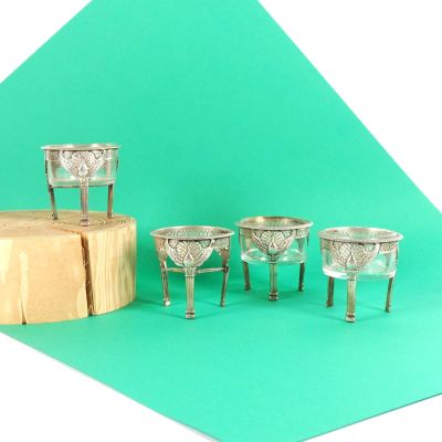 quatre coupes en argent posées sur un socle en bois
