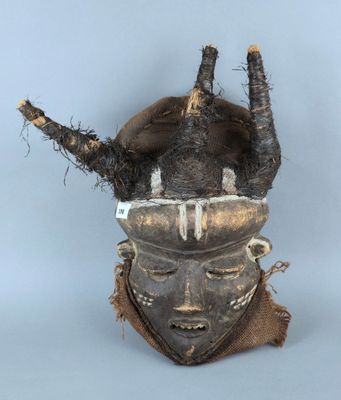 un gros plan d'un masque posé sur une surface blanche, avec un fond bleu