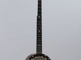 a close up of a banjo hanging from a string on a wall