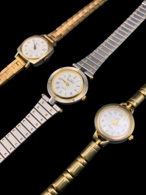 Trois modèles de montres différents sont présentés sur un fond noir