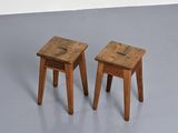 two small wooden stools sitting on top of a gray floor