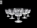 six verres à vin alignés sur un fond noir