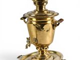 une théière ancienne en laiton posée sur une soucoupe, avec une autre soucoupe en dessous
