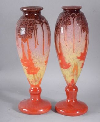 pair of orange and yellow vases sitting on top of a table