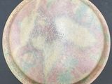 a pink and green plate sitting on a black surface
