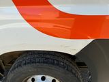 an orange and white bus parked on the side of the road