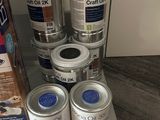 several cans of paint are sitting on a shelf next to a box of paint