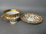 a close up of a cup and saucer on a table
