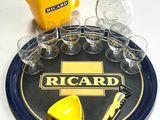 un plateau sur lequel se trouvent des verres, une bouteille, une canette et un décapsuleur