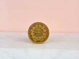 a gold coin sitting on top of a marble counter top